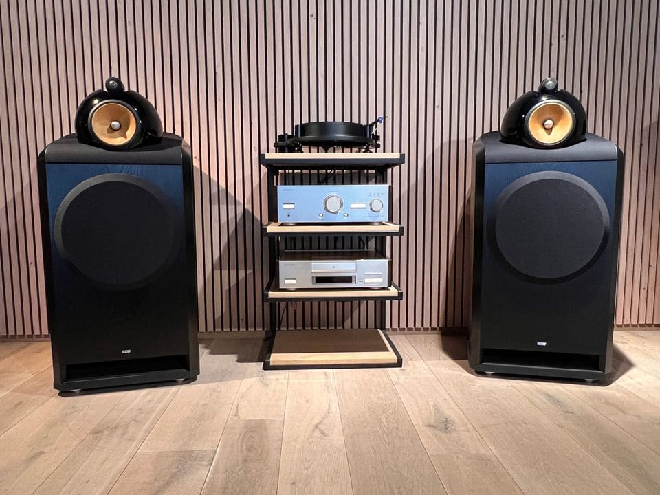 Paar zwarte B&W Nautilus 801 luidsprekers met bolvormige midden- en hoogbehuizing naast een hifi-rek