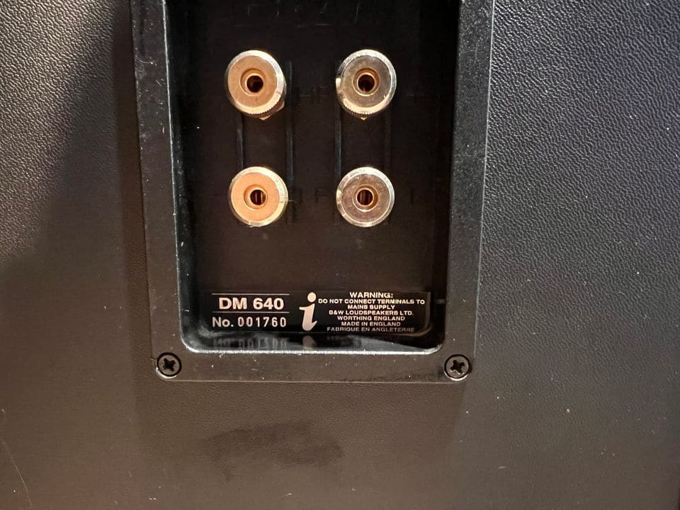 Vergulde bi-wiring terminals en typeplaatje DM 640 op de achterkant
