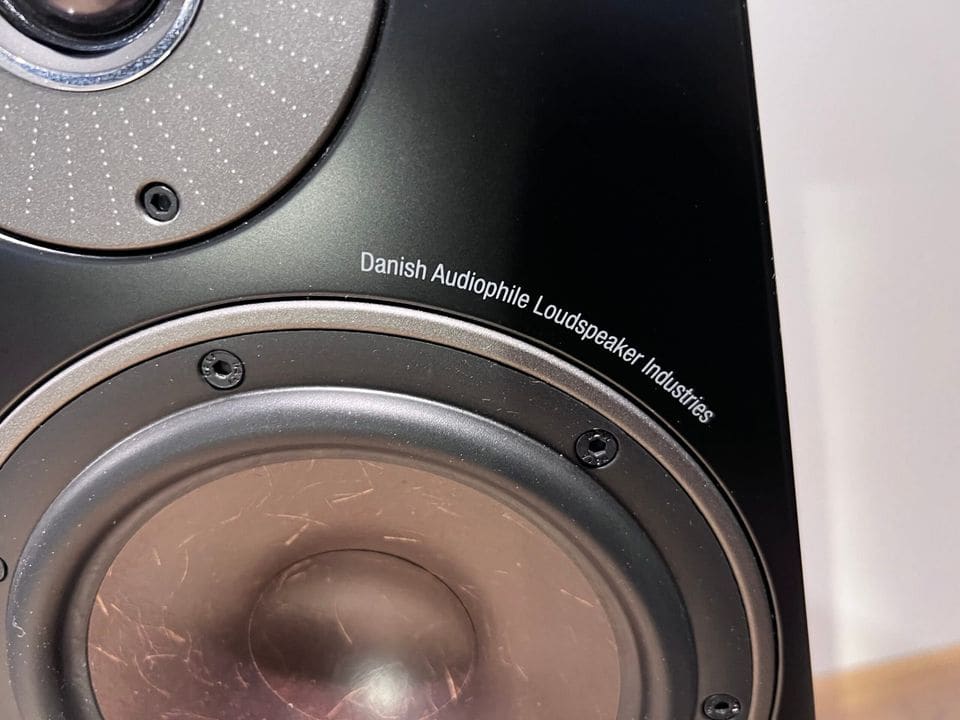 Close-up van de houtvezel-woofer en Danish Audiophile Loudspeaker Industries opschrift