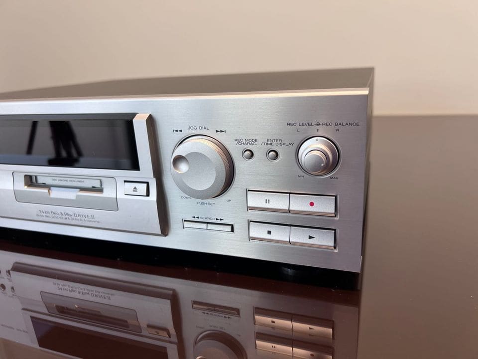Detail van de discsleuf, het draaiwiel en de transporttoetsen van de Kenwood DMF-9020