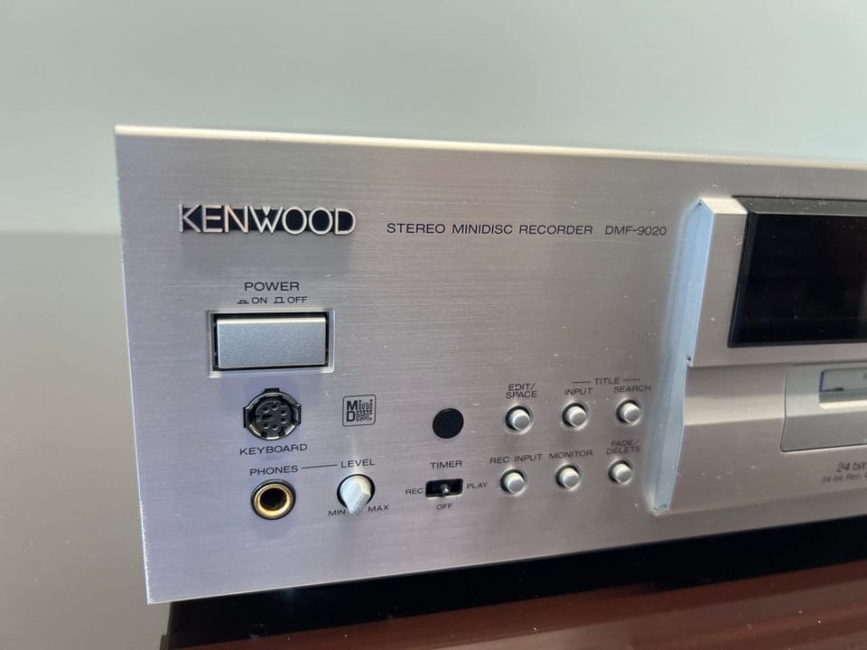 Linkerdeel van het front met Kenwood-logo, aan/uit-knop, keyboard-aansluiting en hoofdtelefoonuitgang