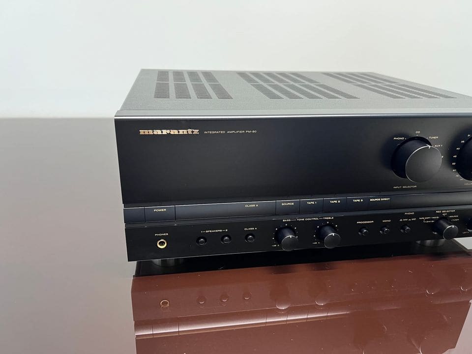 Close-up van het zwarte front van de Marantz PM-80 met ingangskeuze, toonregeling en volumeknop