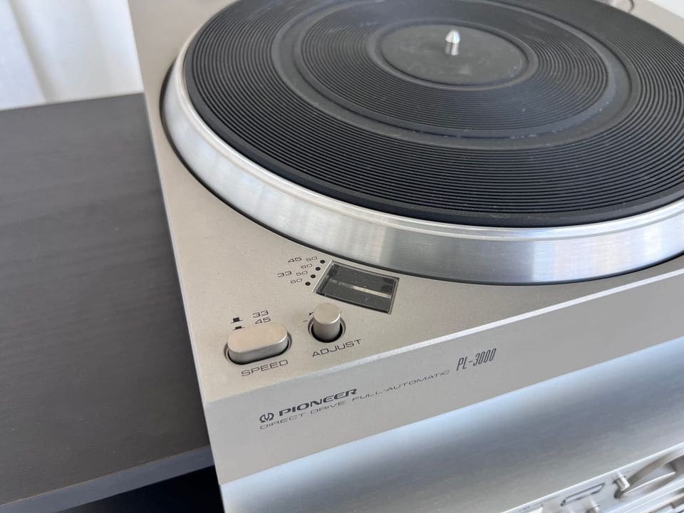 Hoek van de zilveren Pioneer PL-3000 platenspeler met snelheidsknoppen en logo