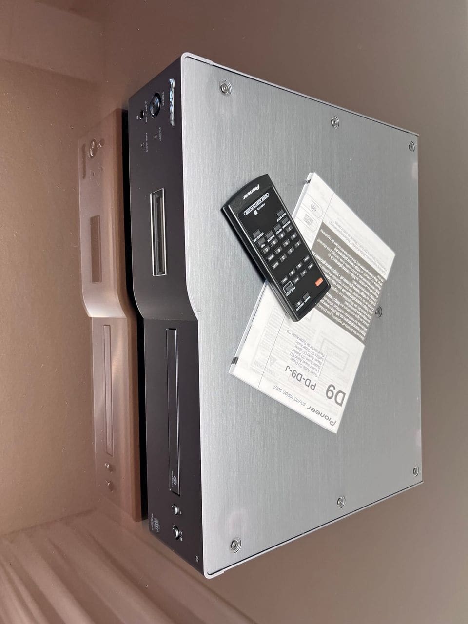 Pioneer PD-D9 op zijn kant met afstandsbediening en handleiding