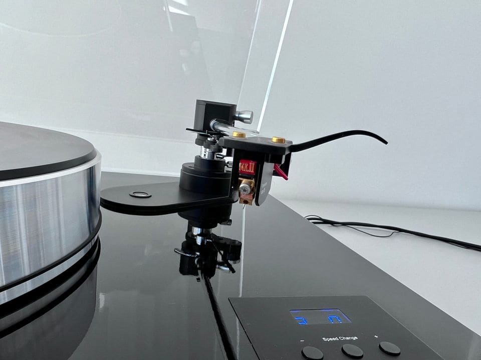 Zijaanzicht van het MC-element en de toonarm naast het aluminium plateau van de Pro-Ject X-tension 12