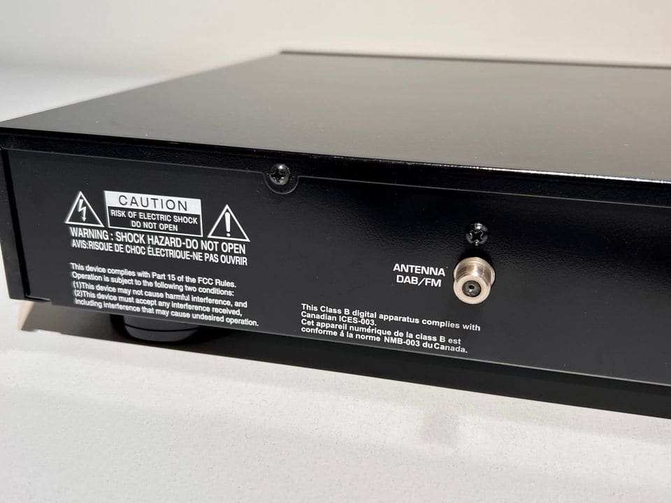 DAB/FM-antenne-aansluiting en waarschuwingslabel op de achterzijde