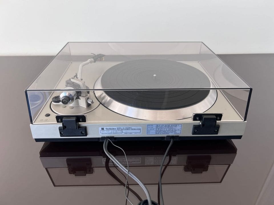 Achterkant van de Technics SL-1400 MK2 met scharnieren van de stofkap en typeplaatje