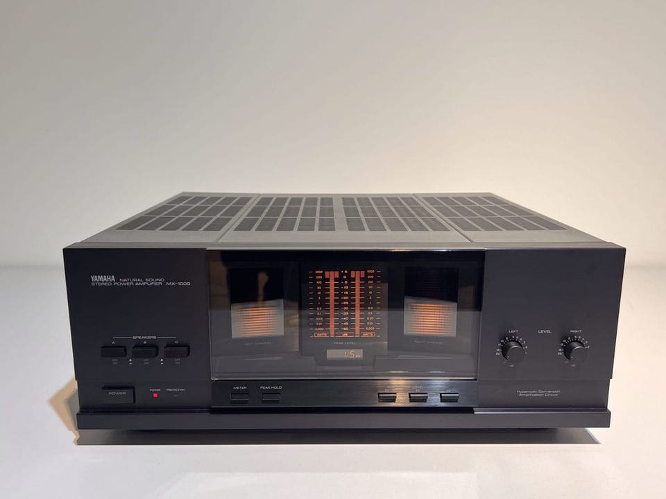 Zwarte Yamaha MX-1000 eindversterker met oranje LED-vermogensmeters, vooraanzicht