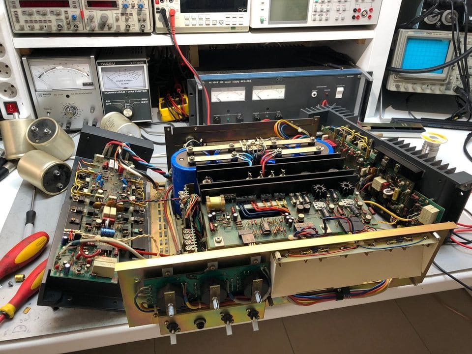 Geopende Revox A740 met uitgeklapte printkaarten en frontplaat, naast twee uitgebouwde oude elco's