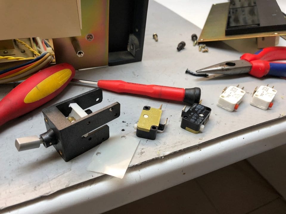 Gedemonteerd hendelschakelaarblok van de Revox A740 met nieuwe en oude microschakelaars op de werkbank