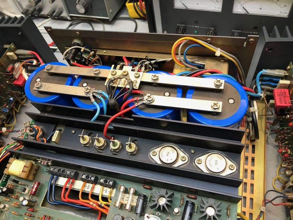 Voeding van de Revox A740 met vier nieuwe blauwe afvlakelco's onder de stroomrails en de koelprofielen